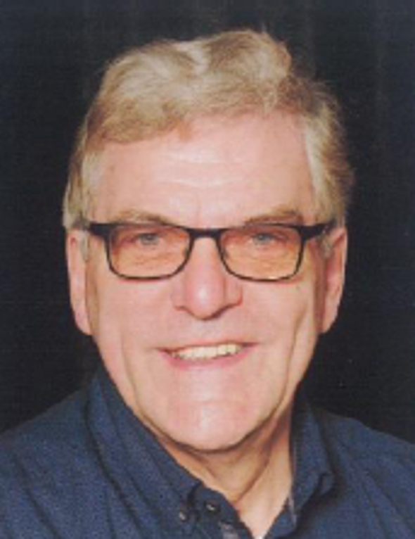 Porträt von Richard Tempel, lächelnd vor neutralem Hintergrund