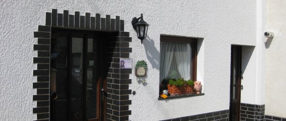 Ferienwohnung Bell weißes Haus mit Eingangstür und Fenster
